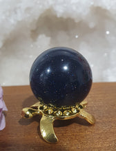 Load image into Gallery viewer, Blue Sandstone Sphere Crystal Carving on Gold Turtle Stand | Inspires Concentration and Courage
Beautiful Blue Sandstone Sphere Crystal Carving on Gold Stand in the shape of a turtle. This is so lovely and sparkly.