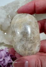 Load image into Gallery viewer, Lovely Moonstone Palm Stone Crystal Carving on plastic stand. Inspires Divine Connection and Clarity