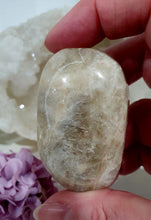 Load image into Gallery viewer, Lovely Moonstone Palm Stone Crystal Carving on plastic stand. Inspires Divine Connection and Clarity
