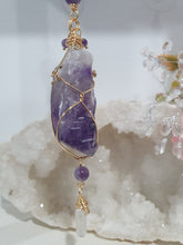Load image into Gallery viewer, THE MYSTIC AWAKENING" Handcrafted Amethyst Raw Crystal Stone Gold Crystal Energy Enhancer© Hanger Ornament Suncatcher
INSPIRES INTUITION, WISDOM AND SPIRITUALITY
Stunning Raw Amethyst crystal stone beaded with Amethyst and Quartz. Wire wrapped in gold.