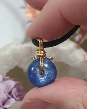 Load image into Gallery viewer, Stunning Blue Kyanite crystal stone donut crystal carving wire wrapped in non tarnish gold wire. Come with a black cork necklace.