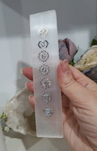 Load image into Gallery viewer, Selenite Cleansing Crystal Slab with Silver Chakra Symbols Stone. Inspires Connection to the Angelic Realms
Beautiful Selenite Slab with Embossed Chakra Symbols.. Perfect to cleanse your space and crystals