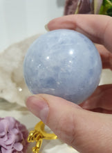 Load image into Gallery viewer, Celestite Sphere Crystal Carving on Gold Stand. Inspires Communication with the Angels
