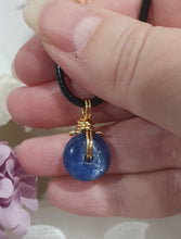 Load image into Gallery viewer, Stunning Blue Kyanite crystal stone donut crystal carving wire wrapped in non tarnish gold wire. Come with a black cork necklace.
