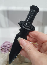 Load image into Gallery viewer, Beautiful polished Black Obsidian Athame (Dagger) Crystal Carving Stone.
INSPIRES PROTECTION AND BALANCE
An Athame is a ceremonial knife used in spiritual rituals to direct energy, cast circles, and represent the element of fire or air, but it is typically not used for physical cutting.
Stunning polished Black Obsidain Athame Dagger Crystal Carving.