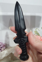 Load image into Gallery viewer, Beautiful polished Black Obsidian Athame (Dagger) Crystal Carving Stone.
INSPIRES PROTECTION AND BALANCE
An Athame is a ceremonial knife used in spiritual rituals to direct energy, cast circles, and represent the element of fire or air, but it is typically not used for physical cutting.
Stunning polished Black Obsidain Athame Dagger Crystal Carving.