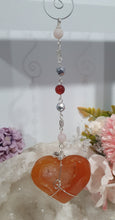 Load image into Gallery viewer, HEART OF LOVE & SEDUCTION" - - Carnelian Heart Silver Wired Stone Crystal Energy Enhancer© Hanger Suncatcher Ornament 200mm | Inspires Sensuality, Love & Stability
INSPIRES SENSUALITY | LOVE | STABILITY
Carnelian heart Crystal Energy Enhancer© / Hanger / Ornament beaded with Carnelian, Rose Quartz, Hematite, Herkimer Diamonds and quartz. wired in silver