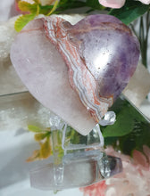 Load image into Gallery viewer, Amethyst Agate Heart Crystal Carving Stone on plastic Stand
Inspires intuition and Emotional Well Being
Beautiful Polished Amethyst Agate Heart Crystal Carving on plastic stand. Has natural formations.