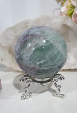 Load image into Gallery viewer, Beautiful Fluorite Sphere Crystal Carving on Silver Stand. Inspires Stability, Grounding and Concentration. Lovely patterns and colouring with inclusions.