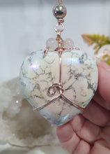 Load image into Gallery viewer, HEART OF A UNICORN" Aura Howlite Heart Stone Rose Gold Crystal Energy Enhancer© Hanger Ornament Suncatcher
INSPIRES MAGICK AND LOVE
Gorgeous Aura Howlite Heart beaded with Rose Quartz, Rainbow Hematite and Quartz. Wired in Rose Gold