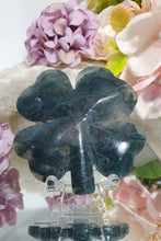 Load image into Gallery viewer, Beautiful polished Moss Agate Four Leaf Clover Crystal Carving on plastic stand. Insoires tranquility and grounding.
HAS A SMALL CRACK on front and a lovely druzy on back