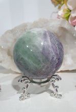 Load image into Gallery viewer, Beautiful Fluorite Sphere Crystal Carving on Silver Stand. Inspires Stability, Grounding and Concentration. Lovely patterns and colouring with inclusions.