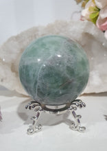 Load image into Gallery viewer, Beautiful Fluorite Sphere Crystal Carving on Silver Stand. Inspires Stability, Grounding and Concentration. Lovely patterns and colouring with inclusions.