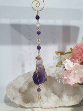 Load image into Gallery viewer, THE MYSTIC AWAKENING" Handcrafted Amethyst Raw Crystal Stone Gold Crystal Energy Enhancer© Hanger Ornament Suncatcher
INSPIRES INTUITION, WISDOM AND SPIRITUALITY
Stunning Raw Amethyst crystal stone beaded with Amethyst and Quartz. Wire wrapped in gold.