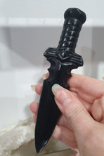 Load image into Gallery viewer, Beautiful polished Black Obsidian Athame (Dagger) Crystal Carving Stone.
INSPIRES PROTECTION AND BALANCE
An Athame is a ceremonial knife used in spiritual rituals to direct energy, cast circles, and represent the element of fire or air, but it is typically not used for physical cutting.
Stunning polished Black Obsidain Athame Dagger Crystal Carving.