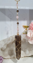 Load image into Gallery viewer, WAND OF STRENGTH" Handcrafted Smoky Quartz Tower Point Stone Gold Crystal Energy Enhancer© Hanger Ornament Suncatcher
Inspires GROUNDING | LOVE | STABILITY
Gorgeous Smoky Quartz crystal tower beaded with Smoky Quartz, Rose Quartz and Herkimer Diamond. Wire wrapped in gold