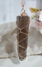 Load image into Gallery viewer, WAND OF STRENGTH" Handcrafted Smoky Quartz Tower Point Stone Gold Crystal Energy Enhancer© Hanger Ornament Suncatcher
Inspires GROUNDING | LOVE | STABILITY
Gorgeous Smoky Quartz crystal tower beaded with Smoky Quartz, Rose Quartz and Herkimer Diamond. Wire wrapped in gold