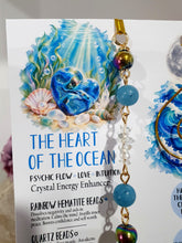 Load image into Gallery viewer, HEART OF THE OCEAN" Handcrafted Titanium Aura Sphalerite Heart Stone Crystal Carving Gold Crystal Energy Enhancer© / Hanger / Ornament / Suncatcher
Inspires PSYCHIC FLOW | LOVE | INTUITION
Gorgeous Titanium Aura Sphalerite heart crystal carving beaded with Aquamarine, Rainbow Hematite & Quartz. Wire wrapped in gold