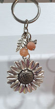 Load image into Gallery viewer, THE SUNFLOWER KEEPER" Metal Sunflower with Sunstone Beads Crystal Keyring.
Choose from Gold of Silver medal colour.
INSPIRES JOY | HOPE | OPTIMISM
Carry a little Sunshine wherever life takes you!
"The sunflower has long symbolised joy, hope and unwavering optimism. Like the flower that turns towards the sun, it reminds us to keep looking for the light, even through life's difficult seasons".
Gorgeous Metal sunflower Keyring Key ring beaded with AAA sunstone faceted beads.