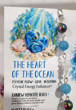 Load image into Gallery viewer, HEART OF THE OCEAN" Handcrafted Titanium Aura Sphalerite Heart Crystal Carving Silver Crystal Energy Enhancer© / Hanger / Ornament / Suncatcher
Inspires PSYCHIC FLOW | LOVE | INTUITION
Gorgeous Titanium Aura Sphalerite heart crystal carving stone beaded with Aquamarine, Rainbow Hematite & Quartz. Wire wrapped in silver