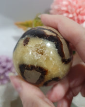 Load image into Gallery viewer, Septarian (Dragon Stone) Egg Crystal Carving Stone on Stand.
Grounds & Nurtures
Beautiful Polished Septarian Egg Crystal Carving on plastic stand. Has natural divits formations. Madagascar sourced.
Known as the Dragon Stone. Formed 70 million years ago from volcanic mud and sea life. These polished egg shaped feature cracked patterns of yellow Calcite, brown Aragonite and grey Limestone.The egg shape symbolises new beginnings, the "unfolding of energy from within,".