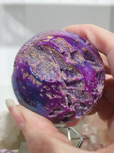 Load image into Gallery viewer, Pink Titanium Aura Sphalerite Sphere Crystal Carving on Silver Stand.
PROMOTES PSYCHIC DEVELOPMENT AND UPLIFTS
Absolutely Stunning Pink Titanium Aura Sphalerite Crystal Sphere on Silver Sand. The druzy on this in insane!.