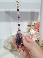 Load image into Gallery viewer, THE MYSTIC AWAKENING" Handcrafted Amethyst Raw Crystal Stone Gold Crystal Energy Enhancer© Hanger Ornament Suncatcher
INSPIRES INTUITION, WISDOM AND SPIRITUALITY
Stunning Raw Amethyst crystal stone beaded with Amethyst and Quartz. Wire wrapped in gold.