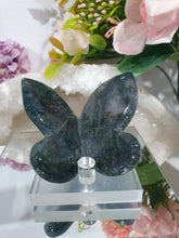 Load image into Gallery viewer, Butterfly Moss Agate Crystal Carving Stone on Stand. Inspires tranquility and grounding.

Beautiful polished Moss Agate Butterfly Crystal Carving on plastic stand
