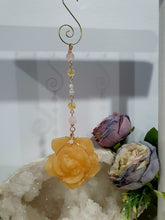 Load image into Gallery viewer, Stunning "ROSE OF SUNSHINE" Handcrafted Orange Calcite Rose Carving gold Crystal Energy Enhancer© Hanger Ornament Suncatcher. hang in your room or space. Inspires Joy, cleansing and love
