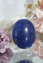 Load image into Gallery viewer, Lapis Lazuli Crystal Palm Stone palm stone on plastic stand. 

INSPIRES HARMONY, WISDOM &amp; PSYCHIC PROTECTION

Lovely Lapis Lazuli Crystal Palm stone with pyrite inclusions on plastic stand. So pretty.  


