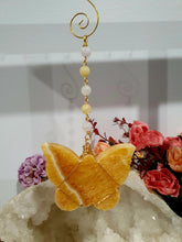 Load image into Gallery viewer, Beautiful polished Butterfly of Joy and manifestation Crystal Energy Enhancer / Sun catcher / Hanger / Ornament. Orange Calcite Butterfly Crystal Carving beaded with golden healer and moonstone.   
