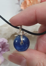 Load image into Gallery viewer, Stunning Blue Kyanite crystal stone donut crystal carving wire wrapped in non tarnish silver wire.  Come with a black cork necklace.
