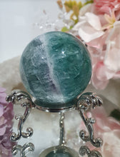 Load image into Gallery viewer, Fluorite Sphere Crystal Carving Stone on Silver Stand

Inspires CONCENTRATION AND STABILITY

Lovely Fluorite Crystal Sphere on silver stand.  super pretty.  Feather fluorite. Amazing pattern.  
