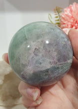 Load image into Gallery viewer, Beautiful Fluorite Sphere Crystal Carving on Silver Stand. Inspires Stability, Grounding and Concentration. Lovely patterns and colouring with inclusions. 

