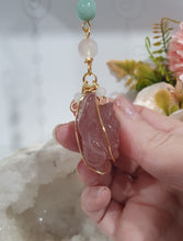 Load image into Gallery viewer, "THE BLUSHING ROSE" Strawberry Quartz Rose Carving gold Crystal Energy Enhancer© Hanger Ornament Suncatcher.

HAPPINESS / LOVE / HARMONY

"THE BLUSHING ROSE - Like the petals of a rose unfolding, The Blushing Rose encourages us to embrace self-love, joy and the beauty within."

Gorgeous Strawberry Quartz Rose Crystal Carving beaded with Ice Pink Malaysian Jade, Rose Quartz, Amazonite and Quartz. Wire wrapped in gold
