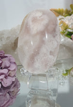 Load image into Gallery viewer, Pink Amethyst / Flower Agate Crystal Palm Stone palmstone on stand.

Inspires ENCOURAGEMENT &amp; SELF DISCOVERY

Pink Amethyst / Flower Agate Crystal Palm stone on plastic stand. So lovely.  
