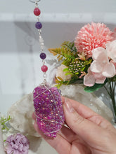 Load image into Gallery viewer, ENCHANTED AURA - Handcrafted Titanium Aura Quartz Crystal Energy Enhancer© / Hanger / Ornament / Suncatcher 

inspires EMPOWERMENT | COMPASSION | MAGICK

Gorgeous Titanium Aura Quartz crystal beaded with Rhodochrosite, Amethyst and Rose Quartz. Wire wrapped in silver

Genuine Crystals. no plastic or glass. Ensuring energy flow throughout the enhancer. Crystal Suncatchers
