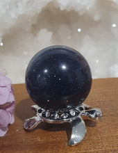 Load image into Gallery viewer, Blue Sandstone Sphere Crystal Carving on Silver Turtle Stand | Inspires Concentration and Courage

Beautiful Blue Sandstone Sphere Crystal Carving on Silver Stand in the shape of a turtle. This is so lovely and sparkly. 

