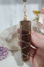 Load image into Gallery viewer, WAND OF STRENGTH" Handcrafted Smoky Quartz Tower Point Stone Gold Crystal Energy Enhancer© Hanger Ornament Suncatcher 

Inspires GROUNDING | LOVE | STABILITY

Gorgeous Smoky Quartz crystal tower beaded with Smoky Quartz, Rose Quartz and Herkimer Diamond.  Wire wrapped in gold
