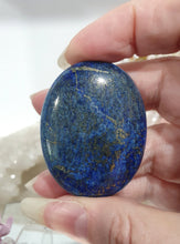 Load image into Gallery viewer, Lapis Lazuli Crystal Palm Stone palm stone on plastic stand. 

INSPIRES HARMONY, WISDOM &amp; PSYCHIC PROTECTION

Lovely Lapis Lazuli Crystal Palm stone with pyrite inclusions on plastic stand. So pretty.  


