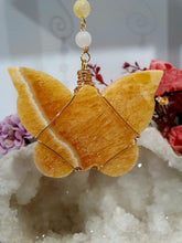 Load image into Gallery viewer, Beautiful polished Butterfly of Joy and manifestation Crystal Energy Enhancer / Sun catcher / Hanger / Ornament. Orange Calcite Butterfly Crystal Carving beaded with golden healer and moonstone.   
