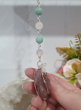 Load image into Gallery viewer, "THE BLUSHING ROSE" Strawberry Quartz Rose Carving silver Crystal Energy Enhancer© Hanger Ornament Suncatcher.

HAPPINESS / LOVE / HARMONY

"THE BLUSHING ROSE - Like the petals of a rose unfolding, The Blushing Rose encourages us to embrace self-love, joy and the beauty within."

Gorgeous Strawberry Quartz Rose Crystal Carving beaded with Ice Pink Malaysian Jade, Rose Quartz, Amazonite and Quartz. Wire wrapped in silver
