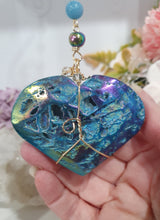 Load image into Gallery viewer, HEART OF THE OCEAN" Handcrafted Titanium Aura Sphalerite Heart Stone Crystal Carving Gold Crystal Energy Enhancer© / Hanger / Ornament / Suncatcher

Inspires PSYCHIC FLOW | LOVE | INTUITION

Gorgeous Titanium Aura Sphalerite heart crystal carving beaded with Aquamarine, Rainbow Hematite &amp; Quartz.  Wire wrapped in gold
