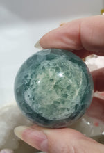 Load image into Gallery viewer, Fluorite Sphere Crystal Carving Stone on Silver Stand

Inspires CONCENTRATION AND STABILITY

Lovely Fluorite Crystal Sphere on silver stand.  super pretty.  Feather fluorite. Amazing pattern.  
