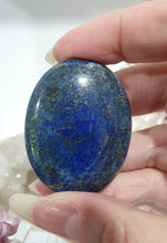 Load image into Gallery viewer, Lapis Lazuli Crystal Palm Stone palm stone on plastic stand. 

INSPIRES HARMONY, WISDOM &amp; PSYCHIC PROTECTION

Lovely Lapis Lazuli Crystal Palm stone with pyrite inclusions on plastic stand. So pretty.  


