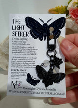 Load image into Gallery viewer, "THE LIGHTSEEKER" Metal Moth Keyring Key chain with Quartz Beads Stone Crystal Key Ring 

INSPIRES GUIDANCE AND TRANSFORMATION

Carry a little Light wherever life takes you!

Gorgeous black coloured metal Moth Keyring Key ring with rose charm, beaded with Quartz.


