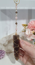 Load image into Gallery viewer, WAND OF STRENGTH" Handcrafted Smoky Quartz Tower Point Stone Gold Crystal Energy Enhancer© Hanger Ornament Suncatcher 

Inspires GROUNDING | LOVE | STABILITY

Gorgeous Smoky Quartz crystal tower beaded with Smoky Quartz, Rose Quartz and Herkimer Diamond.  Wire wrapped in gold
