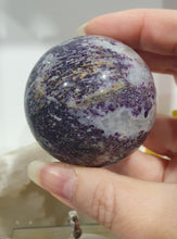 Load image into Gallery viewer, Purple Sphalerite Sphere Crystal Carving on Silver Stand.

Inspires Spirituality &amp; Strength

Stunning Purple Sphalerite Crystal Sphere on Silver Sand. This has a gorgeous quartz vein and pocket of druzy. 
