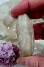 Load image into Gallery viewer, Lovely Moonstone Palm Stone Crystal Carving on plastic stand. Inspires Divine Connection and Clarity
