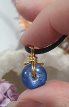 Load image into Gallery viewer, Stunning Blue Kyanite crystal stone donut crystal carving wire wrapped in non tarnish gold wire.  Come with a black cork necklace.
